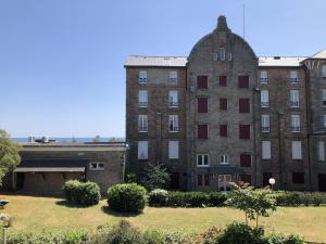 ein großes Backsteingebäude mit einem Hof davor in der Unterkunft Cromlech, Appartement avec petite vue mer, DT170 in Carnac