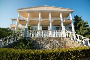a large house with a large porch on a stone wall at Hotel Diamantidis in Myrina