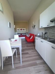 eine Küche mit einem weißen Tisch und einem roten Sofa in der Unterkunft Martylè Rooms in Leverano
