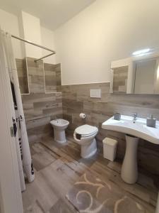 ein Badezimmer mit zwei Waschbecken, einem WC und einem Spiegel in der Unterkunft Martylè Rooms in Leverano