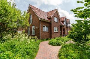 ein Backsteinhaus mit einem Backsteinsteg in der Unterkunft Hus Wittdün Deck 1 Baltrum in Baltrum