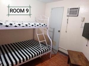 a room with a bunk bed with a room sign at Thirdy's Place Hostel in Legazpi