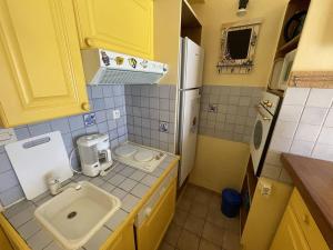 małą kuchnię ze zlewem i lodówką w obiekcie Charmant Pavillon Familial avec Terrasse et Mezzanine - Proche Plage - Saint-Cyprien Plage - FR-1-106-86 w mieście Saint-Cyprien