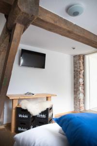 a bedroom with a bed and a tv on the wall at Wattlodge in Norden