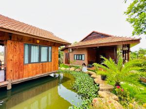 a house with a pond in front of it at BlackPink Homestay Hồ Tràm in Xóm Trương Quít