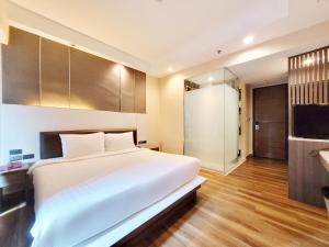 a bedroom with a large white bed and a bathroom at Citin Sukhumvit 11 Nana Bangkok by Compass Hospitality in Bangkok