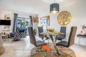 a dining room and living room with a table and chairs at #120 Sunny Balcony with Pools and Golf Course in Albufeira