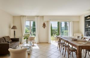una sala de estar con una gran mesa de madera y sillas en Golf Resort & Country Club Saint-Tropez, en Saint-Tropez