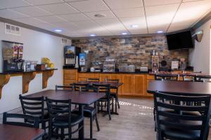 un restaurante con mesas y sillas y un bar en Days Inn & Suites by Wyndham Commerce, en Commerce