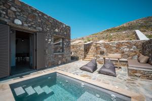 Villa con piscina y pared de piedra. en Petrias Pool House, en Serifos Chora