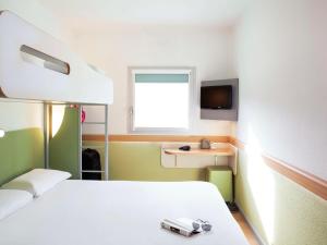 a hospital room with a bed and a tv at ibis budget London Hounslow in Hounslow
