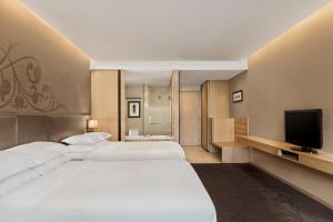 um quarto de hotel com duas camas e uma televisão em Four Points by Sheraton Bangkok, Sukhumvit 15 em Bangkok