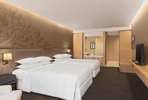 a hotel room with two beds and a television at Four Points by Sheraton Bangkok, Sukhumvit 15 in Bangkok