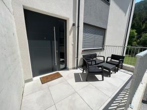a patio with two chairs and a table on a balcony at Apartment 183 Stubaital in Fulpmes