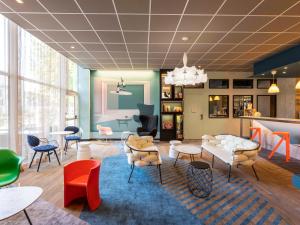 - un salon avec des tables et des chaises colorées dans l'établissement ibis Styles Bordeaux Centre Mériadeck, à Bordeaux