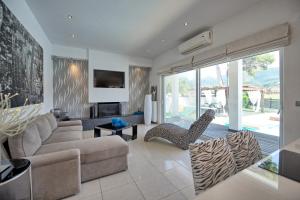 a living room with a couch and a chair at Beach Villa Christina by PosarelliVillas in Acharavi