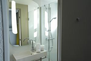 La salle de bains est pourvue d'un lavabo et d'un miroir. dans l'établissement ibis Colmar Centre, à Colmar