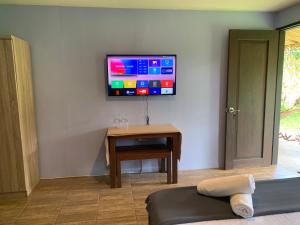 a living room with a tv on the wall at Onur Inn in El Nido