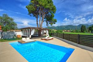 una piscina con gazebo e albero di Beach Villa Christina by PosarelliVillas ad Acharavi