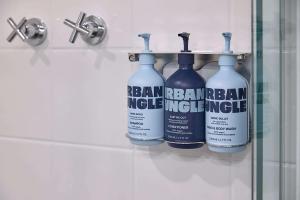 a group of four bottles of cleaning products on a rack in a bathroom at Pensione Hotel Perth in Perth