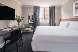 Habitación de hotel con cama grande y escritorio. en Pensione Hotel Perth en Perth