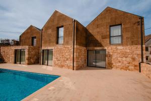 a brick house with a swimming pool in front of it at Chalês - Maria Alva in Marialva