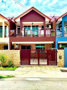 une maison avec une porte rouge en face de celle-ci dans l'établissement Ceria Homestay Putatan, à Putatan