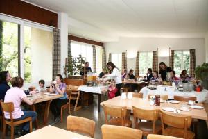 a group of people sitting at tables in a restaurant at Lugano Savosa Youth Hostel in Lugano