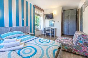 a bedroom with a bed and a chair and a desk at Maestral Residence in Portorož