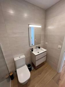 ein Badezimmer mit einem WC, einem Waschbecken und einem Spiegel in der Unterkunft Vistas al Mar in Canales