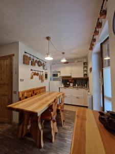 a kitchen and dining room with a wooden table and chairs at L'Atelier du Temps - Treinadan Appartement in Cogne