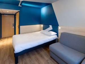 a small room with a bed and a couch at ibis Budget Millau Viaduc in Millau