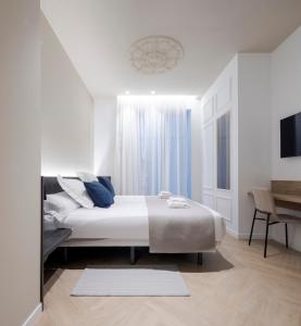 a white bedroom with a bed and a desk at Blanq Ruzafa in Valencia