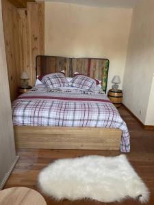 a bedroom with a bed and a white rug at Chaleureuse Maison de pays Serre Chevalier4étoiles in Le Monêtier-les-Bains