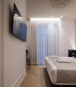 a bedroom with a bed and a television on a wall at Blanq Ruzafa in Valencia