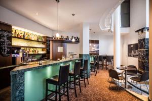 a bar in a restaurant with chairs and tables at Lindner Hotel Dusseldorf Airport, part of JdV by Hyatt in Düsseldorf