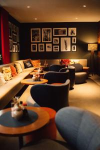 a living room with couches and chairs and tables at me and all hotel Dusseldorf, part of JdV by Hyatt in Düsseldorf