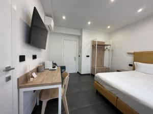 una camera d'albergo con letto, scrivania e cucina di NG Guest House il Gallura a Olbia