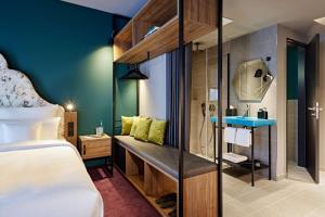 um quarto de hotel com uma cama e uma casa de banho em me and all hotel Dusseldorf Oberkassel, part of JdV by Hyatt em Dusseldorf