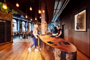 a man standing at a bar in a restaurant at me and all hotel Hanover, part of JdV by Hyatt in Hannover