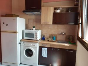 a kitchen with a white refrigerator and a washing machine at Cozy studio flat 1 bedroom-Very central location in Mytilini