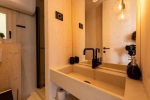 ein Badezimmer mit einem Waschbecken, einer Kamera und einem Spiegel in der Unterkunft BUQEZ VILLAS - VILLA 31 in Drage