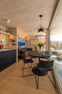 eine Küche und ein Wohnzimmer mit einem Tisch und Stühlen in der Unterkunft BUQEZ VILLAS - VILLA 31 in Drage