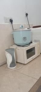 un forno a microonde con una ciotola sopra di Homestay Lestari KLIA a Sepang
