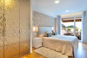 サン・セバスティアンにあるLa Concha Best Viewのベッドルーム1室(ベッド1台付)、スライド式ガラスドアが備わります。