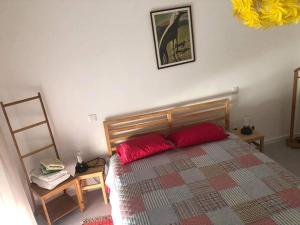 um quarto com uma cama com duas almofadas vermelhas em Braga Forum House em Braga