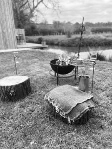 una foto en blanco y negro de una hoguera y troncos en Waters edge en Cucklington