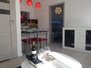 a living room with a table with wine bottles and glasses at Domki Wśród Jabłoni in Gąski