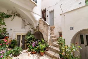 un grupo de macetas en las escaleras de un edificio en Dimora del Vico - Exclusive Terrace with View, en Cisternino