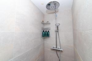 a shower with a shower head and bottles in a bathroom at Dimora del Vico - Exclusive Terrace with View in Cisternino